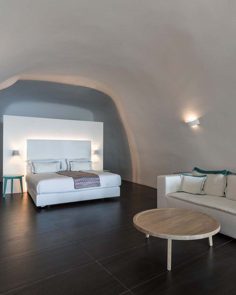 Luxurious Santorini suite with private infinity pool overlooking azure Aegean Sea, white-washed walls, and elegant minimalist design in soft neutrals