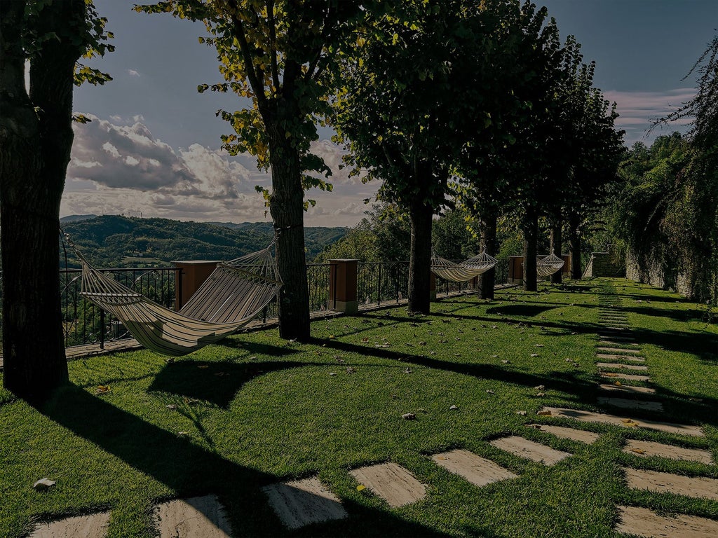 Luxurious stone villa nestled in scenic Italian countryside, featuring elegant architecture, verdant rolling hills, and golden afternoon sunlight