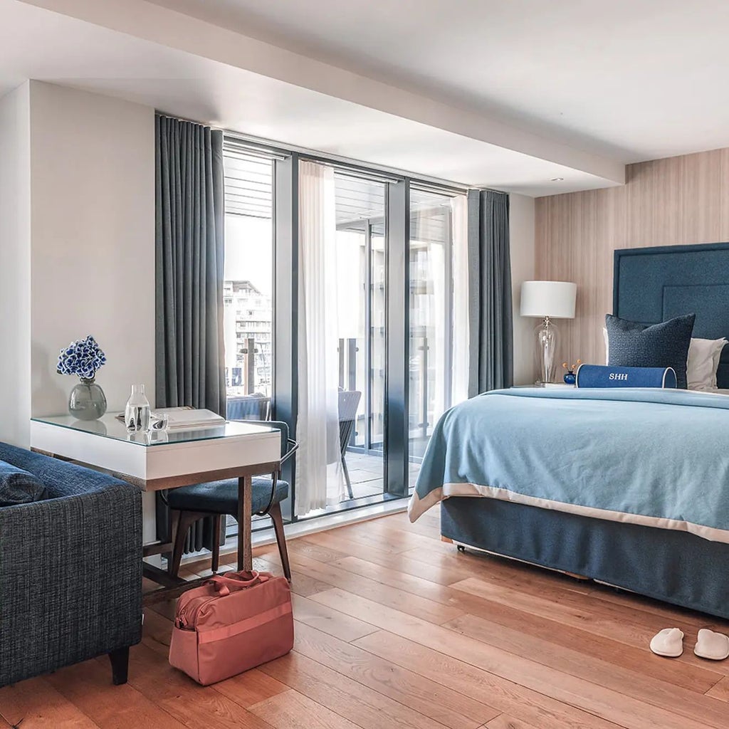 Luxurious marina view suite with private balcony, elegant contemporary design, panoramic waterfront scenery, and modern furnishings in Southampton hotel room