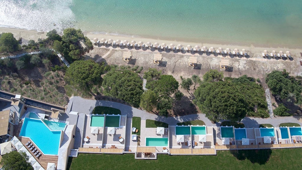 Luxurious white and blue hotel nestled on a cliffside overlooking the turquoise Aegean Sea with modern minimalist architecture and private infinity pool