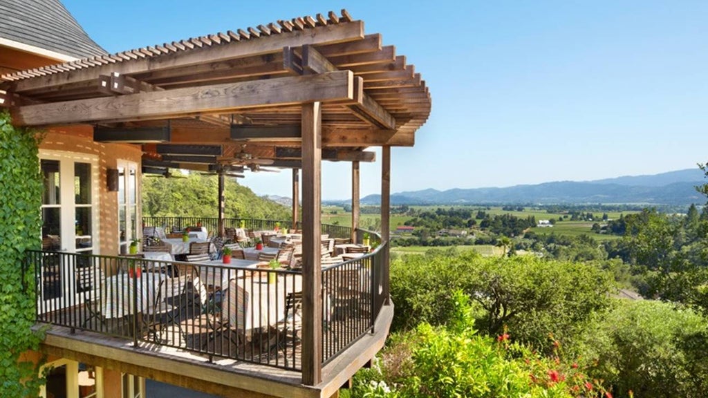 Mediterranean-style luxury hotel nestled in Napa Valley hillside with infinity pool overlooking sun-drenched vineyards and olive groves