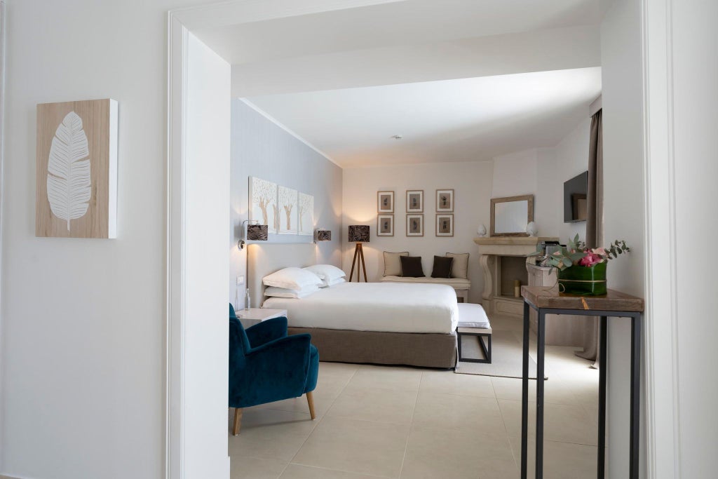 Spacious executive suite at Canne Bianche Lifestyle Hotel, featuring elegant white decor, modern furniture, and a stunning sea view through large windows