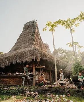 Luxurious open-air hotel room at NIHI Sumba, overlooking lush tropical landscape with wooden deck, infinity pool, and ocean horizon