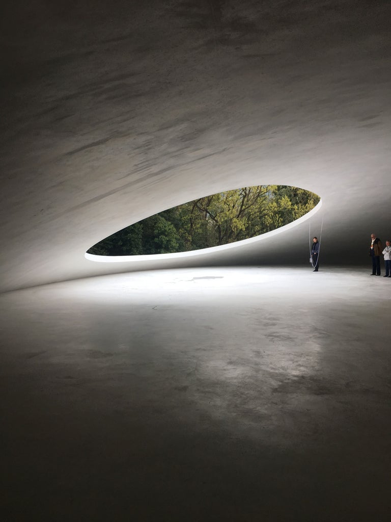 Modern minimalist Japanese written entrance featuring vertical wood paneling, sleek metal text, and soft ambient lighting at dusk