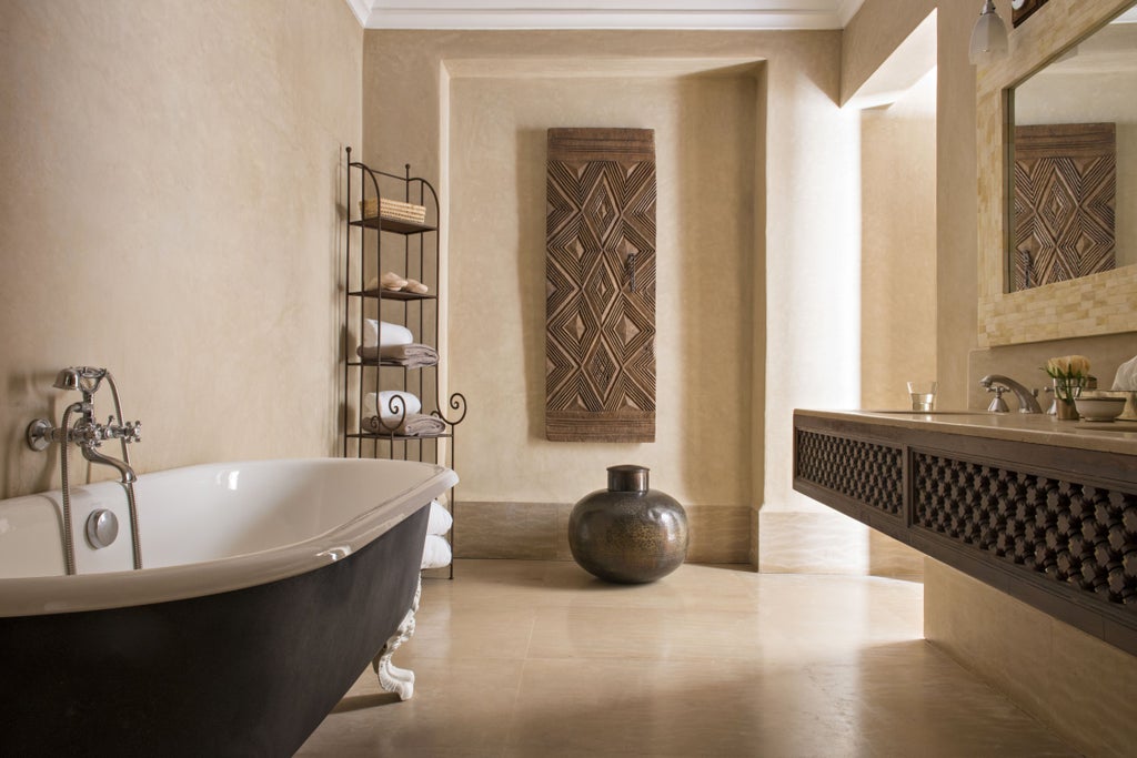 Elegant Moroccan riad with traditional archways, tranquil courtyard pool, ornate tilework, and orange trees in terracotta planters