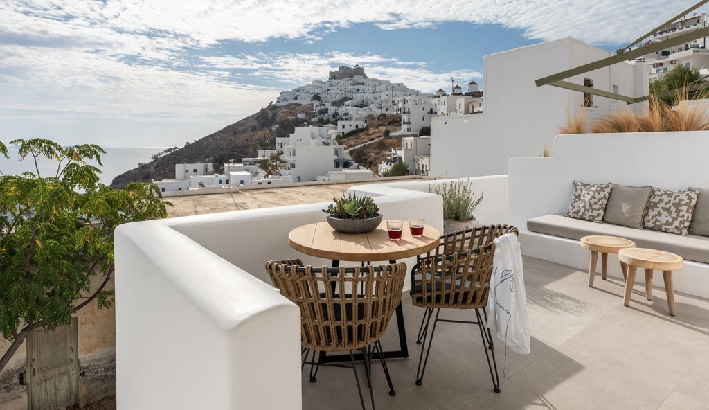 Luxurious white and blue Cycladic-style suites overlooking the azure Aegean Sea, with elegant balconies and traditional Greek architectural details in Stampalia