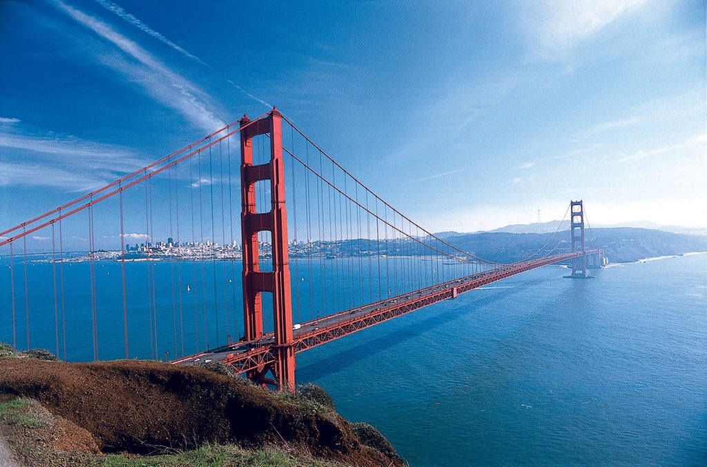 Luxurious high-rise hotel building in downtown San Francisco with modern glass facade, waterfront views and elegant gold-tinted windows