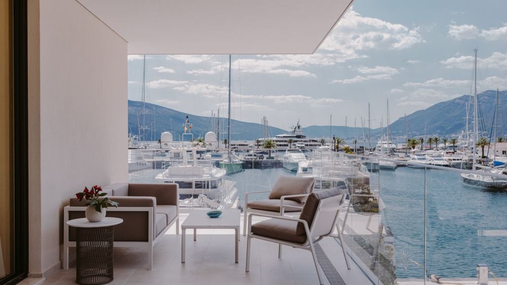 Elegant waterfront hotel with multiple levels of terraces, private marina and mountain backdrop at Porto Montenegro luxury resort