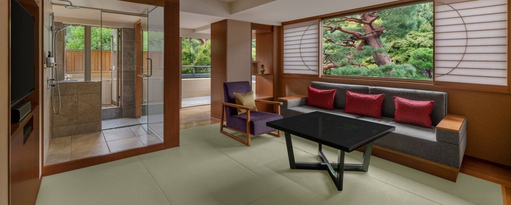 Elegant Japanese-inspired presidential suite with minimalist decor, traditional wood accents, panoramic city view, and luxurious king-sized bed in Kyoto