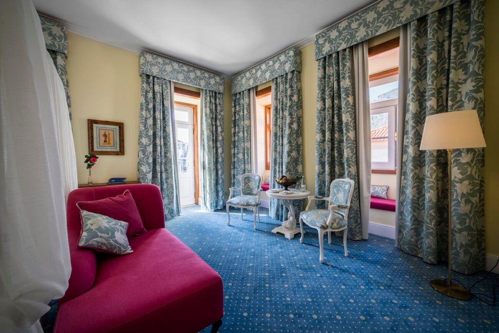 Elegant deluxe suite with vintage charm, featuring plush bedding, wooden floors, and panoramic view of traditional Portuguese architectural landscape