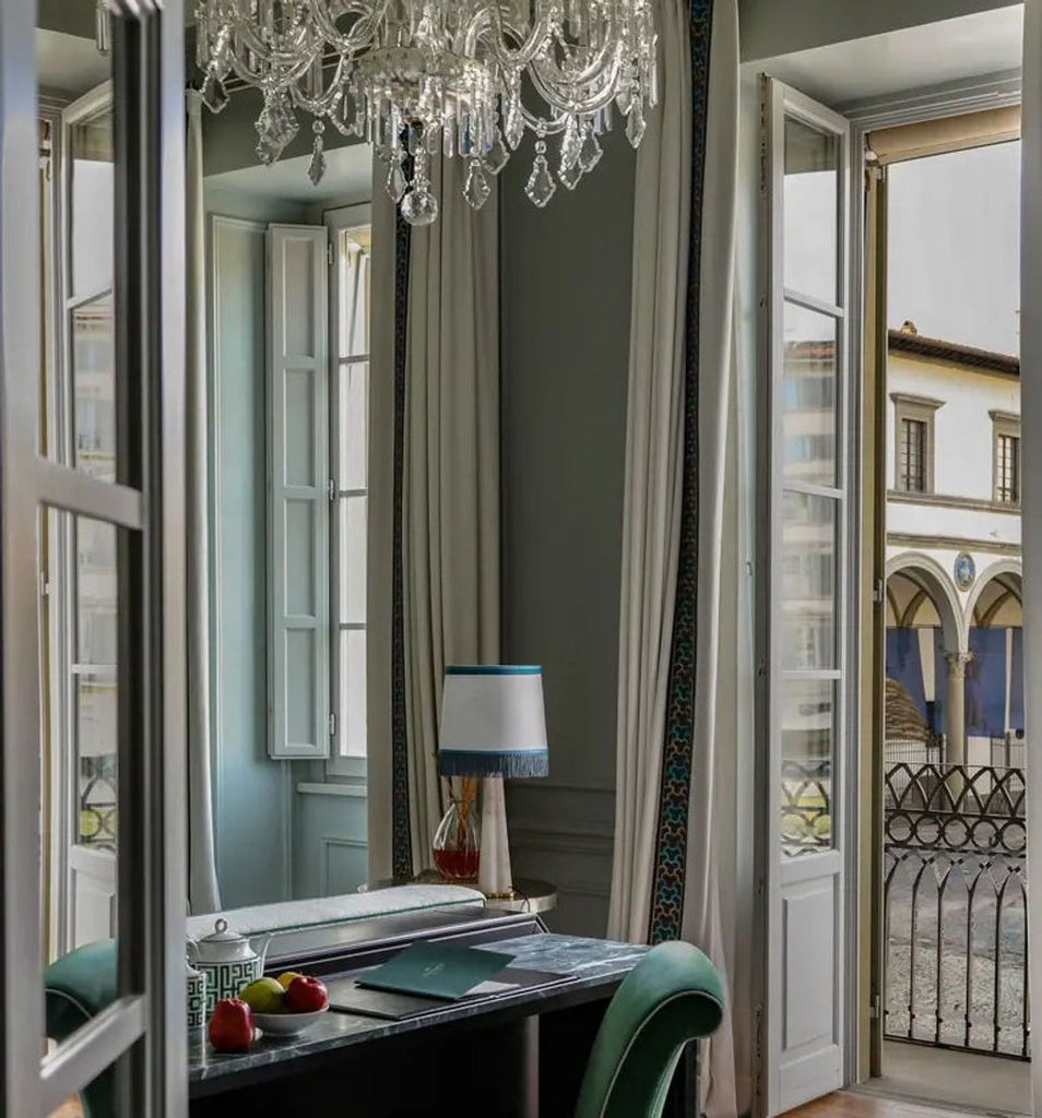 Elegant boutique hotel entrance in Florence with classic arched doorway, ornate iron detailing, and refined stone façade lighting