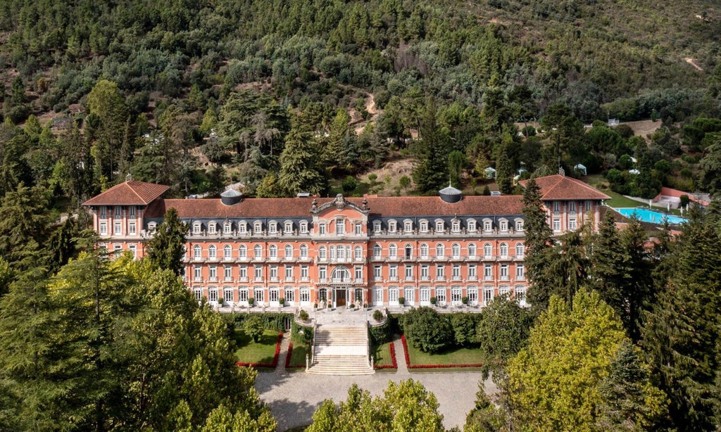 Elegant Art Nouveau palace hotel nestled in lush Portuguese landscape, featuring grand white facade, manicured gardens, and serene architectural grandeur