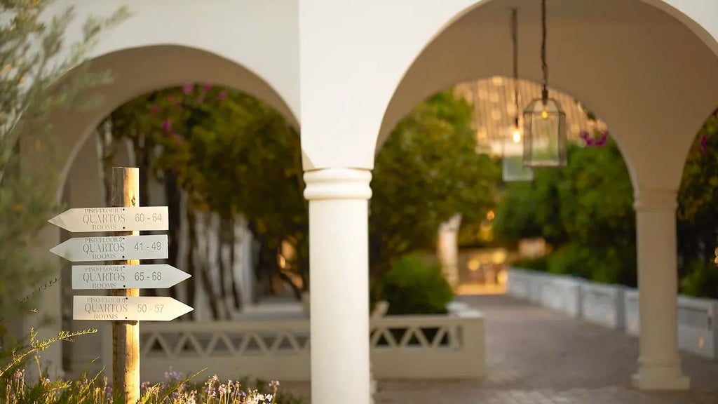 Luxurious whitewashed Portuguese villa with terracotta roofs, surrounded by lush gardens and traditional algarve architectural elements at sunset