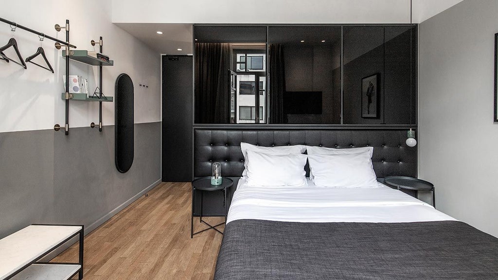 Minimalist hotel room with crisp white linens, sleek wooden furniture, large window overlooking urban scenset, and modern design elements in Thessaloniki