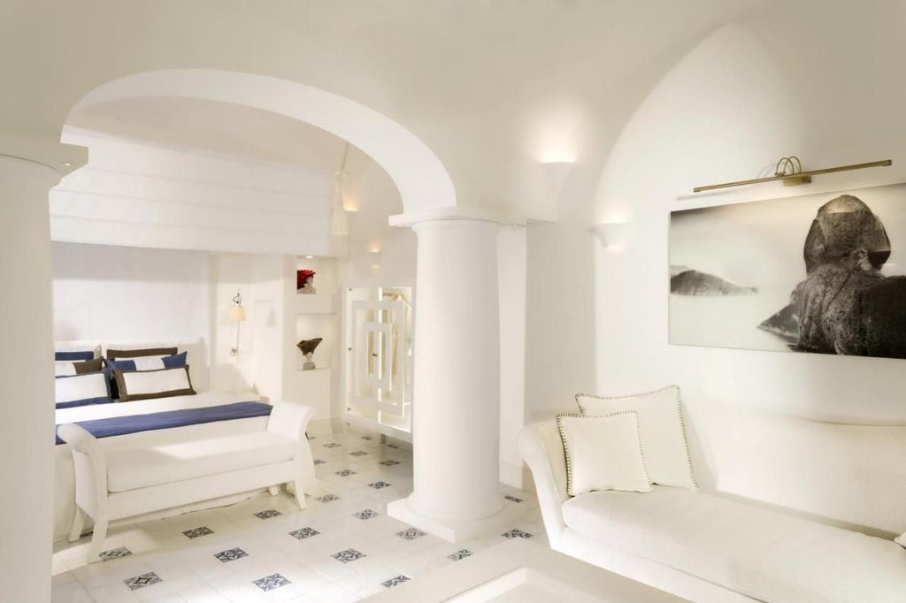 White Mediterranean luxury hotel with elegant stone facade, panoramic sea views, and terraced gardens overlooking Capri's coastal cliffs