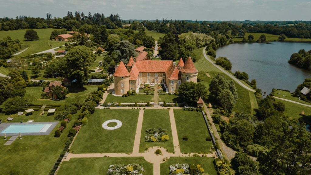 Luxurious French countryside château nestled among verdant meadows, featuring stone architecture, expansive windows, and serene natural surroundings at twilight