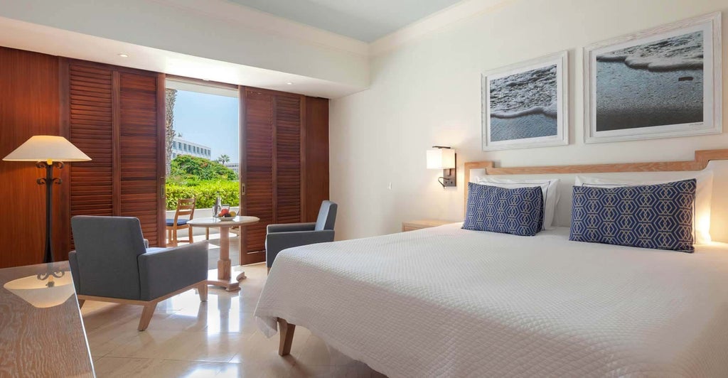 Spacious luxury hotel room with elegant terrace overlooking lush garden, featuring modern decor and Cyprus landscape in soft natural light