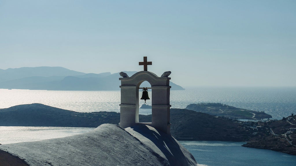 A luxurious Greek taverna overlooking azure Aegean waters, with traditional white-washed buildings and vibrant local cuisine on an elegant outdoor dining terrace.