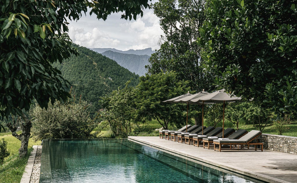 Luxurious mountain lodge with infinity pool overlooking verdant Himalayan valley, traditional Bhutanese architecture blends with modern design