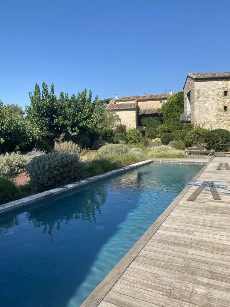 Elegant stone-walled French countryside hotel with lavender fields, rustic stone terrace, and golden sunlight casting warm tones on ancient architectural details