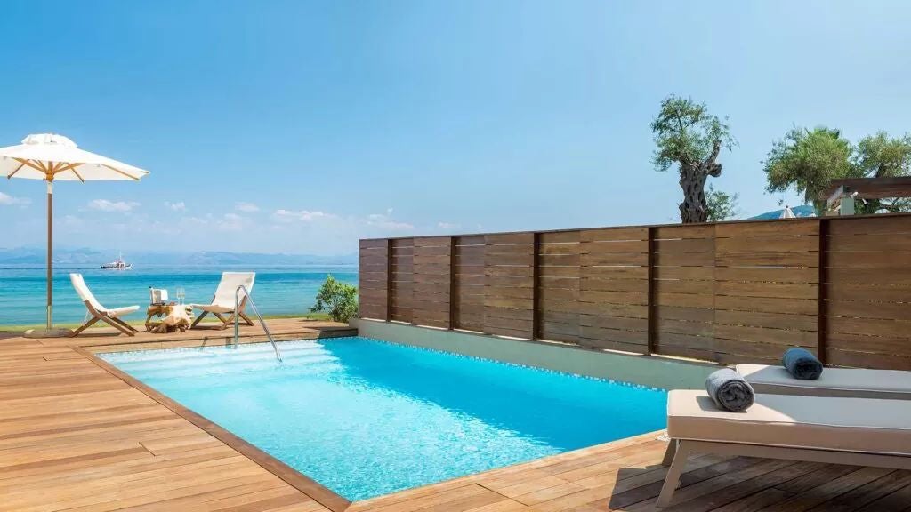 Elegant waterfront resort with modern white architecture, infinity pools and landscaped gardens overlooking the Ionian Sea in Corfu