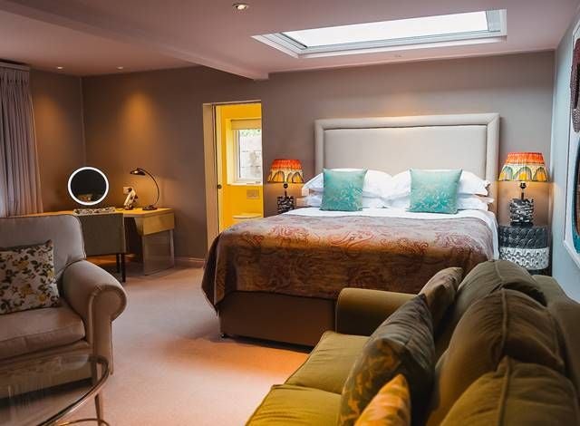 Compact double hotel room with warm wooden accents, minimalist design, cozy bed with crisp white linens, and subtle bird-themed decor in United Kingdom