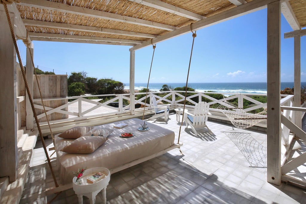 Elegant beachfront cottage with private terrace overlooking Atlantic Ocean, white-washed walls and traditional Moroccan architecture