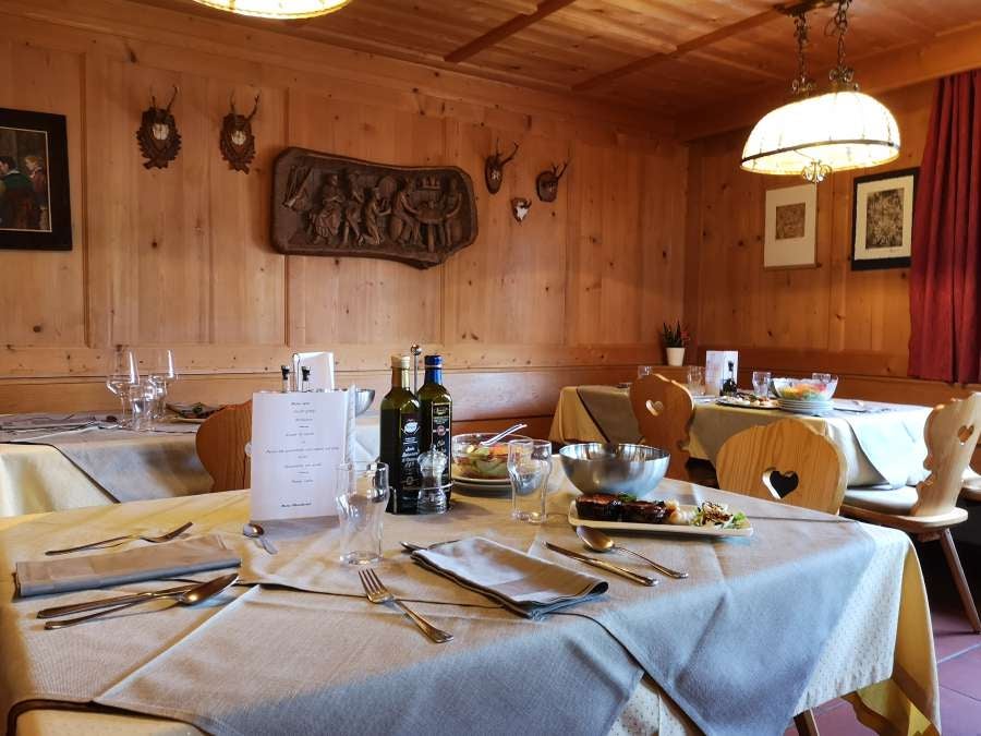 Luxury mountain chalet Fermeda Hut nestled in snow-capped Italian Dolomites, featuring modern architecture and panoramic glass windows