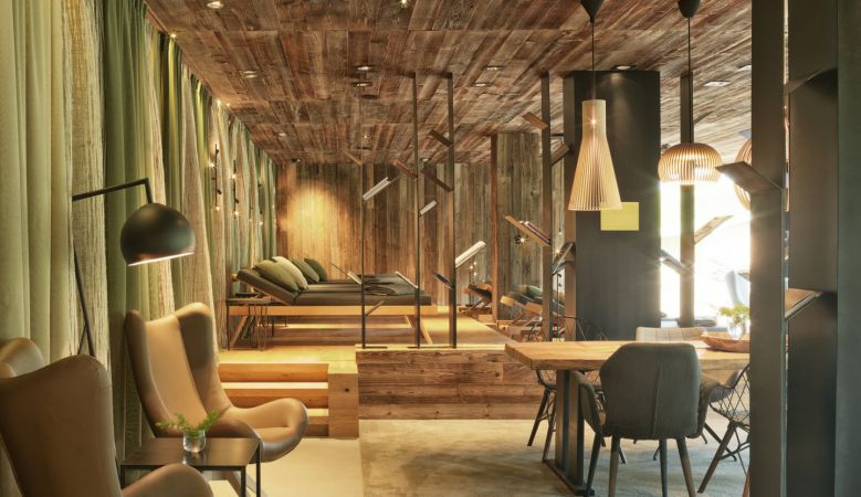 Luxury mountain hotel with infinity pool overlooking snow-capped Austrian Alps, wooden and glass facade nestled in forest setting