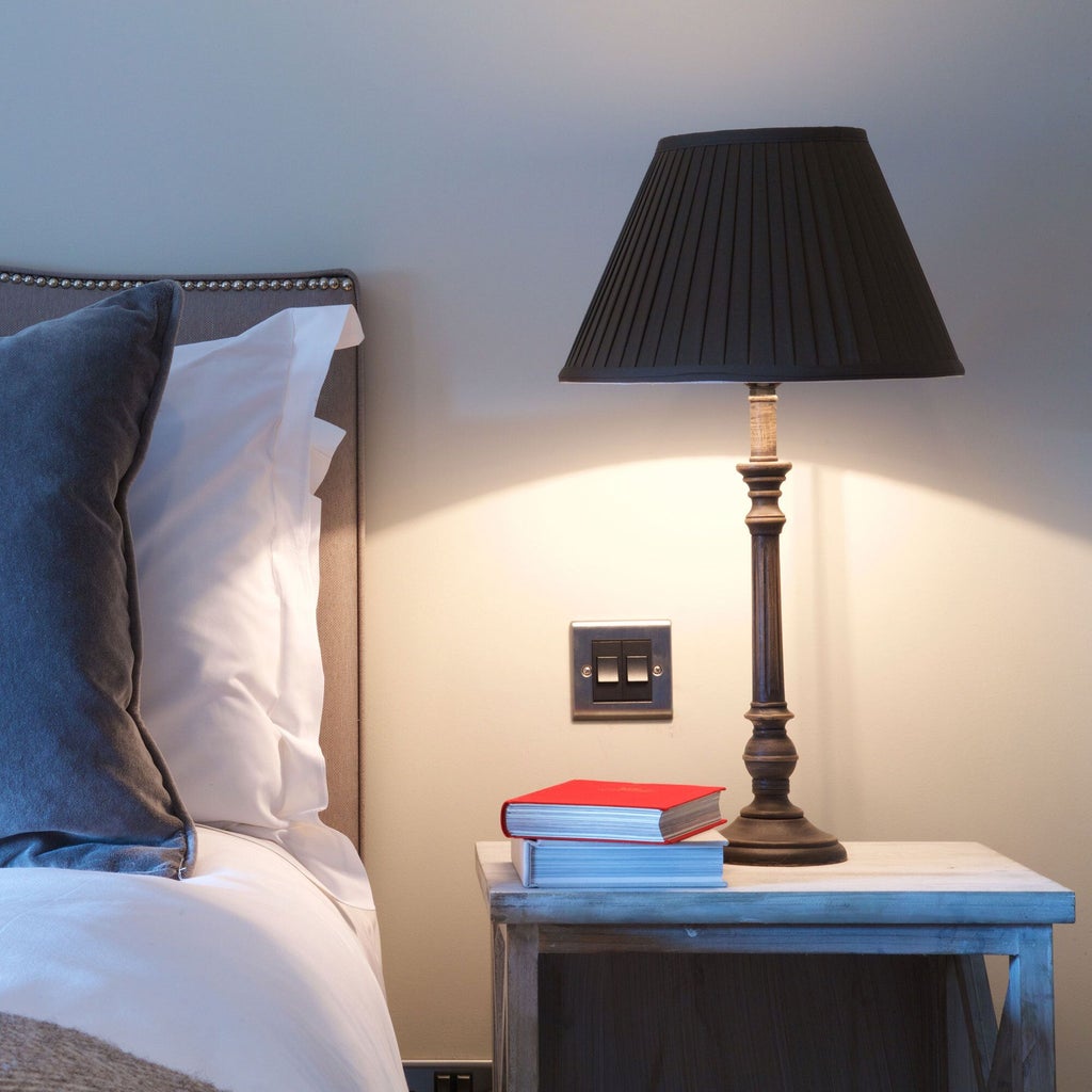 Spacious modern hotel suite with plush king bed, elegant neutral decor, large windows overlooking urban landscape in United Kingdom's Kings Head Hotel