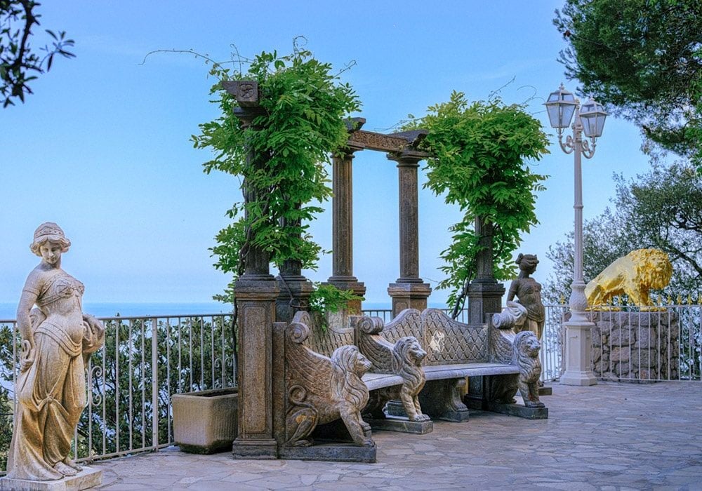 Cliffside luxury hotel with stone walls and terraced gardens overlooking the Mediterranean Sea and medieval village of Èze, France