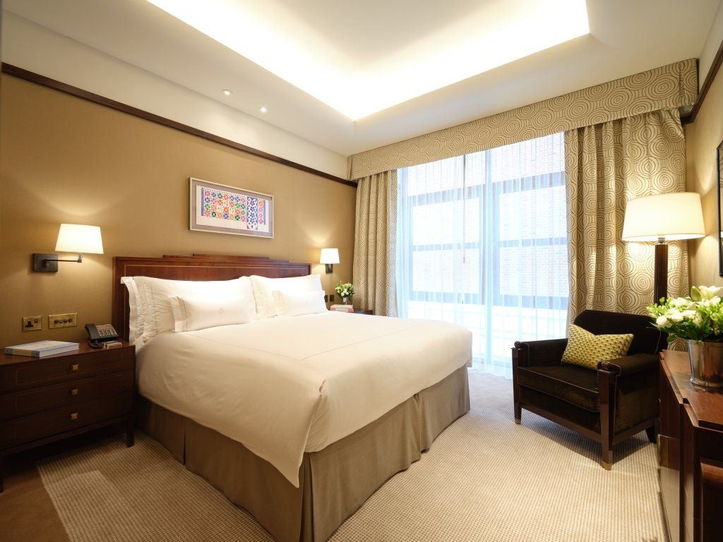 Elegant classic suite at Scenset Mayfair hotel, featuring plush king bed, rich mahogany furnishings, soft neutral color palette, and refined British luxury design