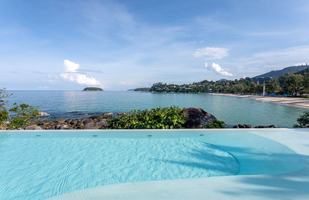 Beachfront luxury villa with private infinity pool overlooking Kata Noi Beach, nestled among tropical gardens at sunset in Phuket