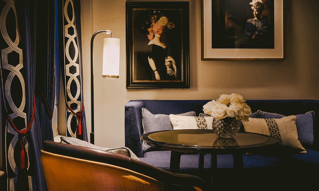 Elegant junior suite with plush king bed, modern grey headboard, luxurious cream furnishings, and chic contemporary decor at The Mayfair Townhouse hotel