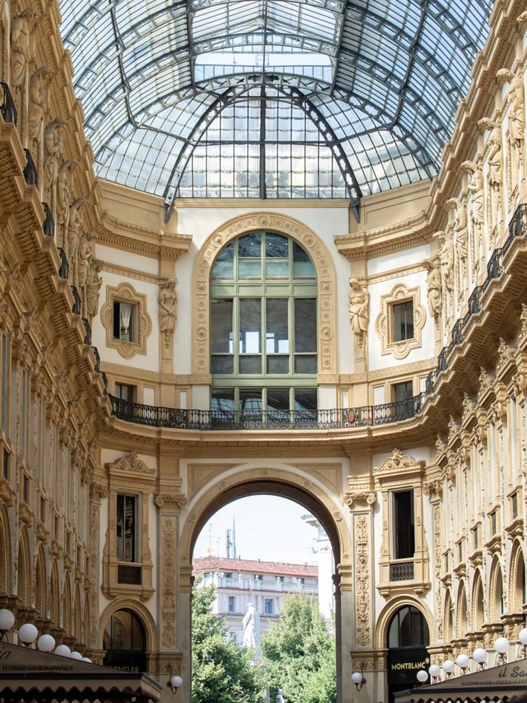 Elegant Italian hotel facade in Milan, featuring luxurious design with glass windows, sleek architecture, and sophisticated urban aesthetic at twilight.