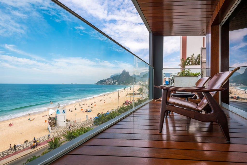 Luxurious rooftop pool overlooking Ipanema Beach, with Art Deco architecture of Fasano Hotel and Rio's stunning coastline in the background