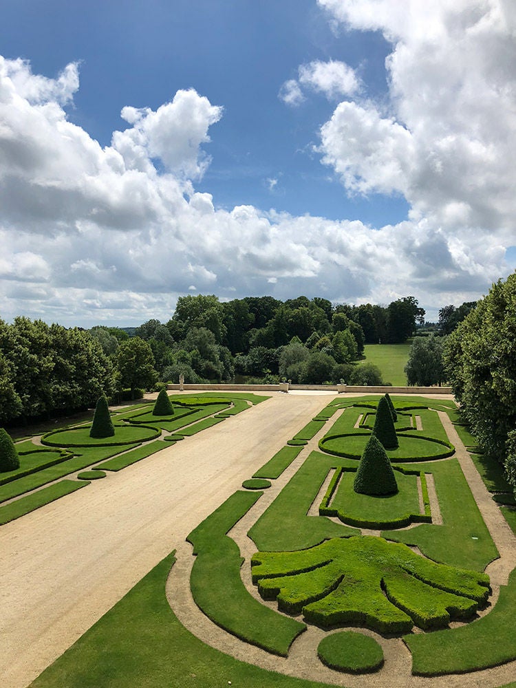 Elegant 18th-century French chateau with limestone facade, ornate windows, and manicured gardens reflecting luxury Loire Valley heritage