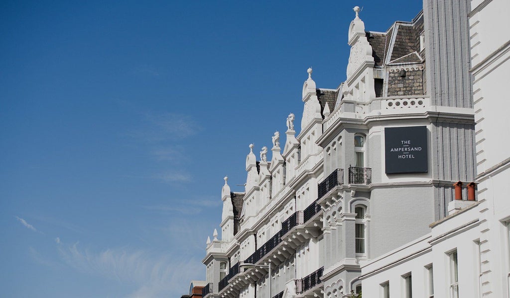 Elegant Victorian facade of The Scenset Hotel in London, with ornate architectural details, warm lighting, and luxurious boutique hotel ambiance at twilight