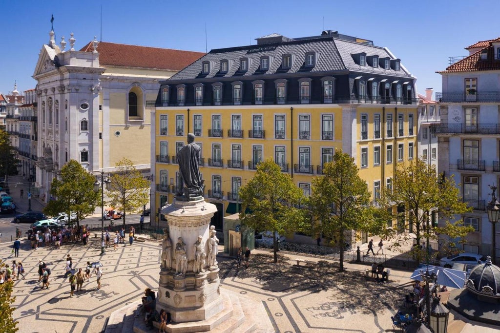 Elegant white stone facade of Bairro Alto boutique hotel in Lisbon, featuring classic architecture, ornate balconies and tall windows