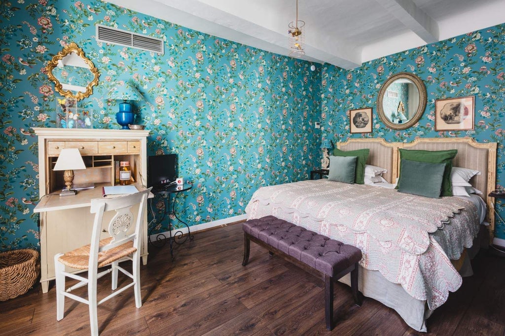 Elegant French country suite with ornate four-poster bed, antique wooden furniture, and soft cream-colored linens in a historic château-style bedroom