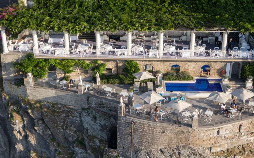 Luxurious terrace overlooking the blue waters of Sorrento, with elegant Mediterranean architecture and stunning coastal cliffs at Hotel Bellevue Syrene