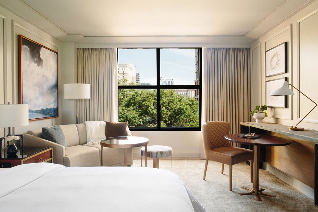 Elegant glass-fronted Four Seasons Austin hotel rises along Lady Bird Lake, featuring modern architecture and landscaped waterfront grounds