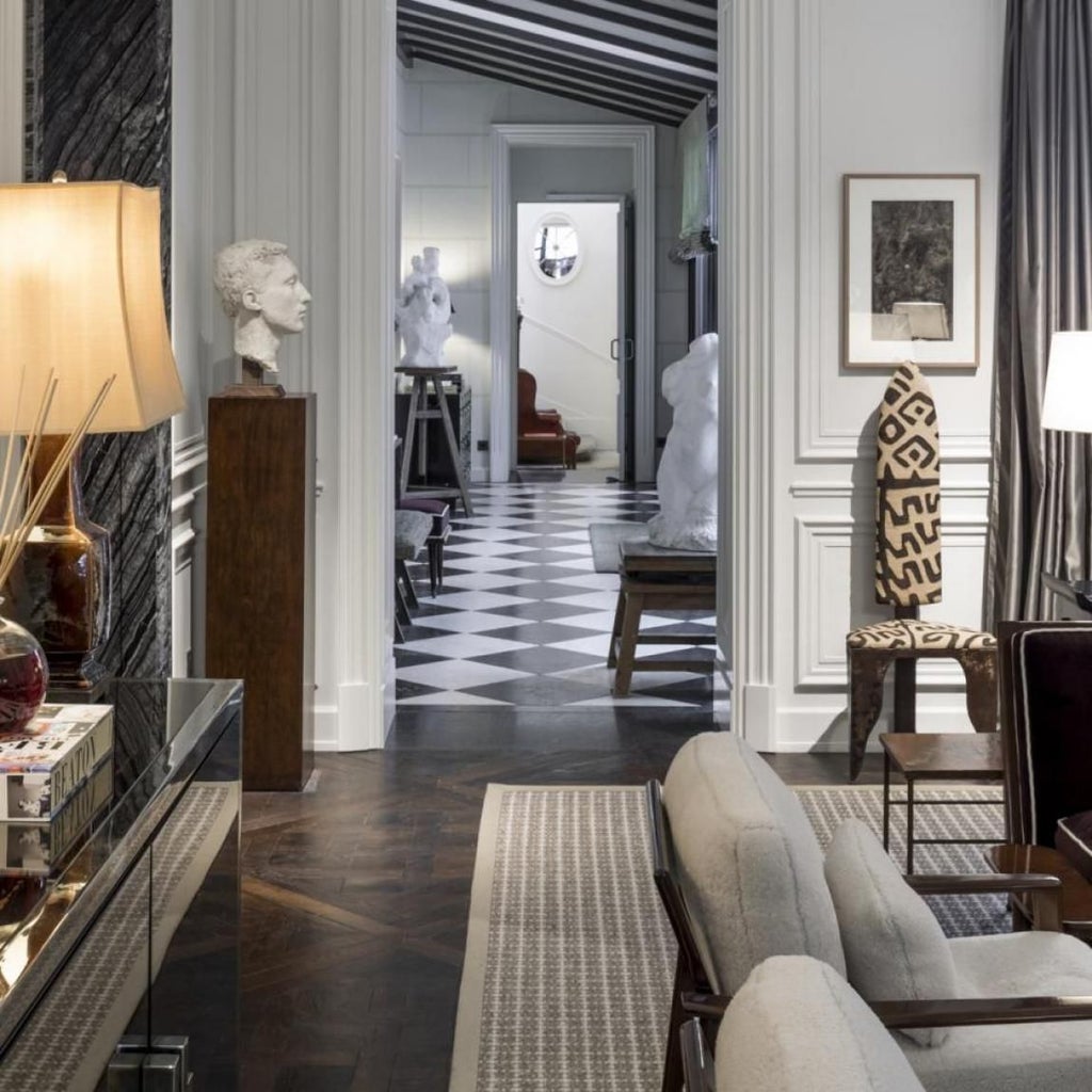 Elegant Parisian hotel interior with plush white seating, soft lighting, and refined marble fireplace showcasing sophisticated French design aesthetic