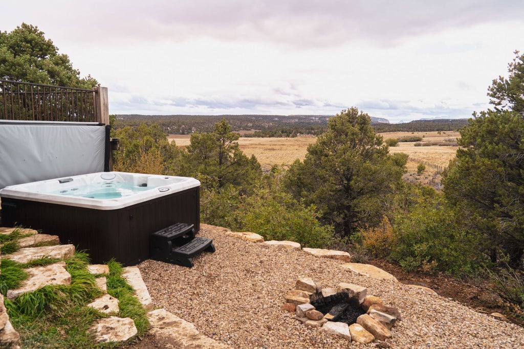 Spacious rustic lodge room with wooden decor, king bed, large windows overlooking scenic mountainous landscape at Scenset Mountain Ranch accommodation