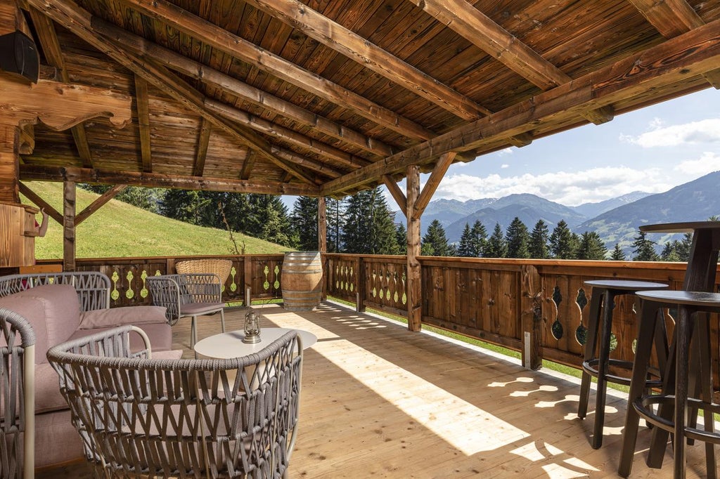 Modern Alpine hotel with wooden balconies and glass facade nestled in snowy mountains, featuring panoramic views and luxury design