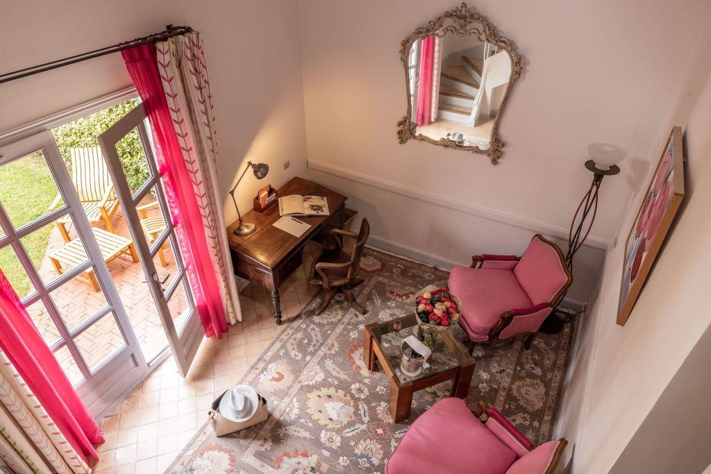 Elegant French provincial hotel room with soft beige linens, antique wooden furniture, and soft natural light streaming through delicate curtains