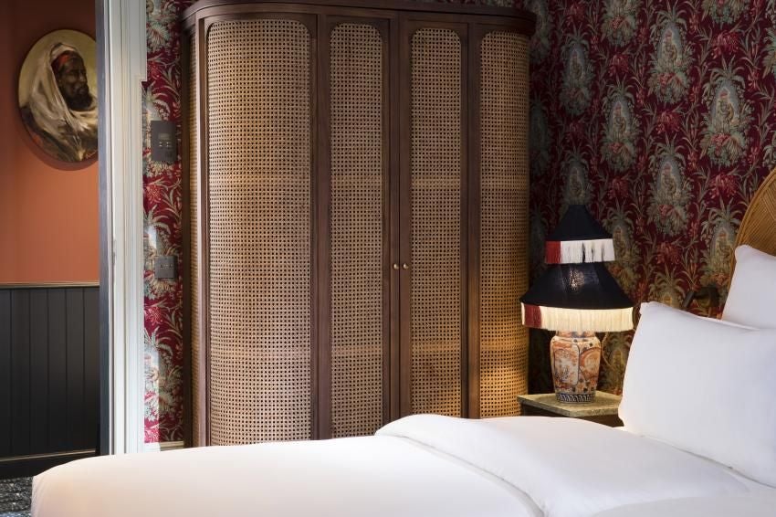 Elegant classic hotel room with soft neutral tones, plush bedding, vintage-inspired furnishings, and subtle Parisian charm at Hotel Monte Cristo