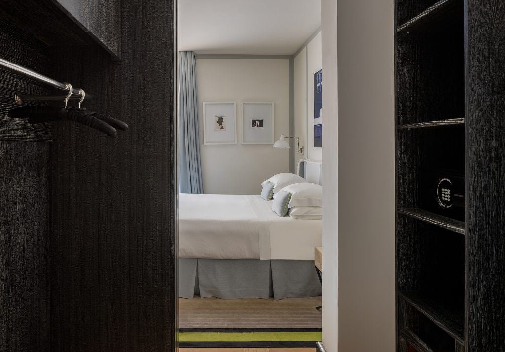 Elegant studio deluxe hotel room with modern Italian design, private terrace overlooking scenic urban landscape in Roma with soft natural lighting.