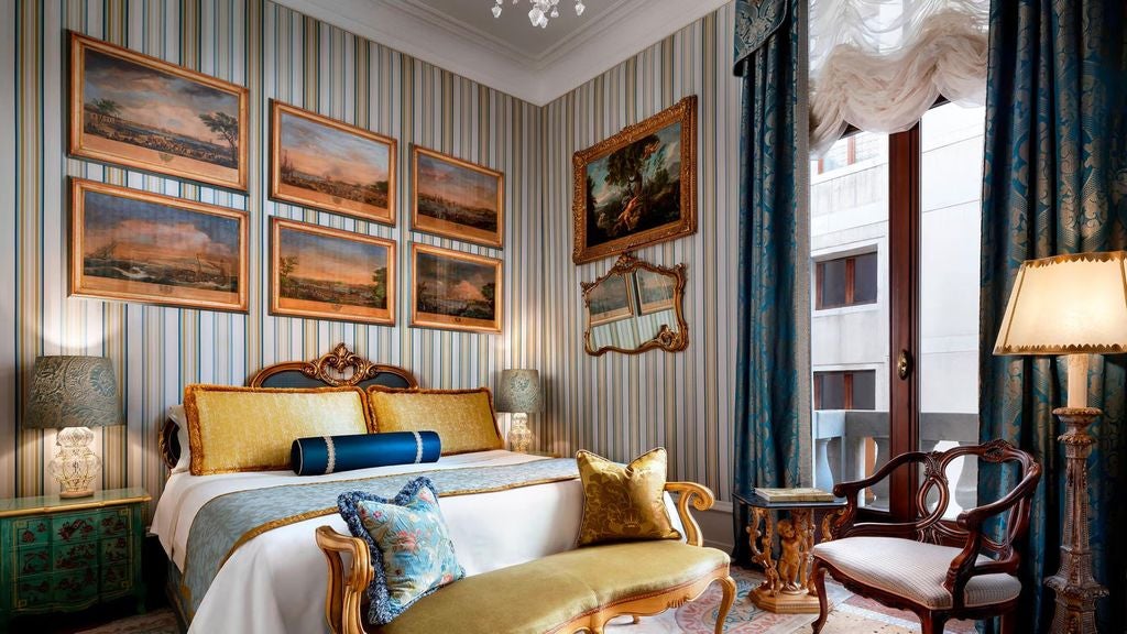 Opulent Venetian suite with crystal chandelier, antique furnishings, silk damask walls and grand canal views through tall windows