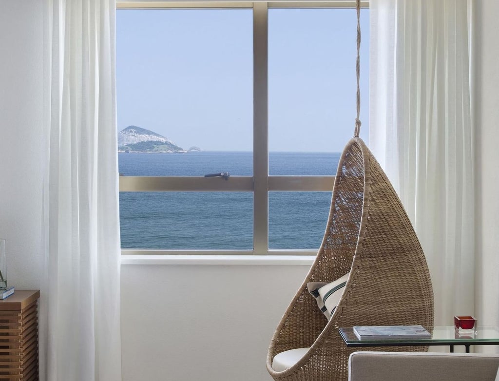 Spacious modern suite at Janeiro Hotel, featuring panoramic ocean views, sleek minimalist design, and elegant Brazilian coastal aesthetic with natural light